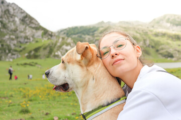 Happiness of a young girl and a dog traveling through the mountains