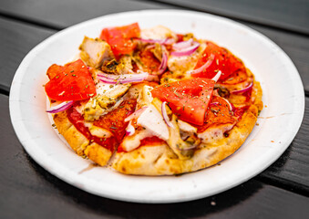 pita pizza with Mozzarella cheese, ham, mushrooms, salami. Italian pizza on wooden table background outdoor