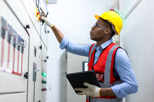 Electrical engineer working in control room. Electrical engineer man checking Power Distribution Cabinet in the control room
