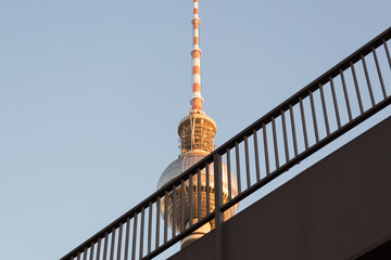 Fernsehturm in berlin behinde a handrail against the blue sky