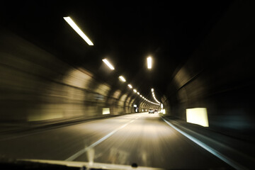 driving through an illuminated tunnel, point of view, motion blur