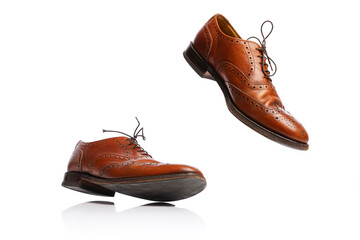 Flying man's brown classic style shoes over white background. Vintage dress shoes. Concept of ad, sales , fashion, retro vintage style