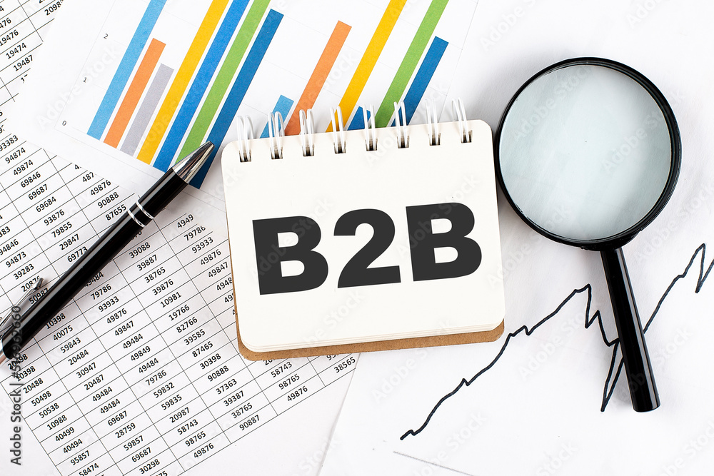 Poster b2b text on notebook on the graph background with pen and magnifier