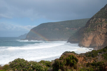 Fototapeta na wymiar Maingon Bay Australia, view of waves breaking along coastline with rainbow over water