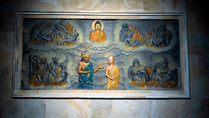 A painting on a wall in a Buddhist temple with a buddha and the history of his arrival and life. A...