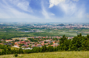 Town Plovdiv with houses and fields against backdrop of Rhodope Mountains and hills covered with forests and cloudy sky
