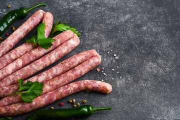Raw sausages. Bratwurst or sausages with ingredients on cutting board with spices on a stone...