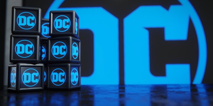 Stacked digital blocks displaying logo of DC Comics against blurred backdrop. Editorial illustration