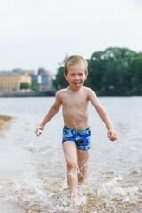 Happy boy child enjoys water