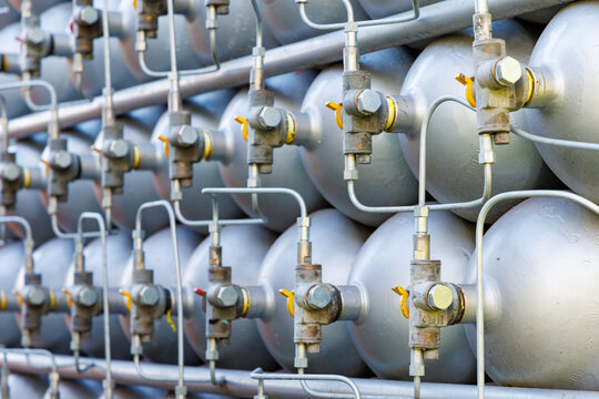 A lot of bottles filled with gas or gasoline are stacked in piles