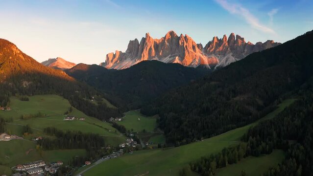 Val Di Funes, Dolomites, Italy - 4K Flying towards and descending at St. Johann Church (Chiesetta di San Giovanni in Ranui) in South Tyrol with the Italian Dolomites at background 