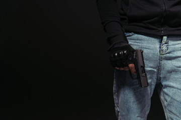 Cropped view of african american hooligan holding handgun isolated on black - obrazy, fototapety, plakaty