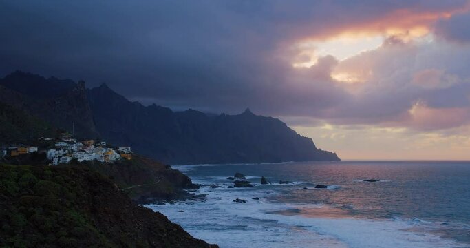 Picturesque Almaciga village on cliffs at cloudy dark sunset, Tenerife Island, Canaries, Europe. View of mountains landscape with settlement houses at Atlanic ocean, 4k footage.