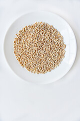 Pearl barley on a white plate close-up
