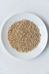Pearl barley on a white plate close-up