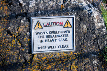 Waves Sweep Over The Breakwater In Heavy Seas metal sign on the Cornish coast