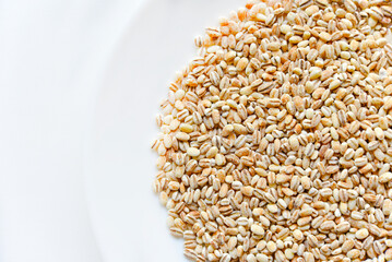 Pearl barley on a white plate close-up