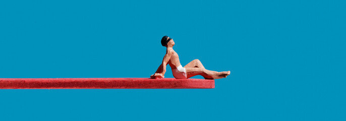 miniature man sitting on a diving board, banner