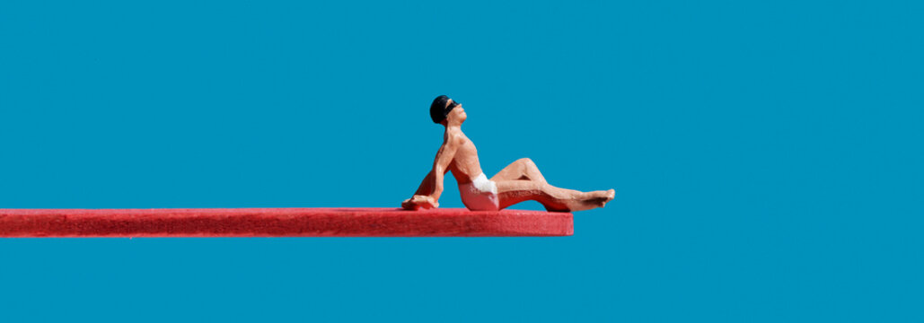 miniature man sitting on a diving board, banner