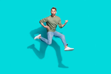 Full length profile photo of inspired sportsman jump play imaginary guitar wear pullover isolated blue color background