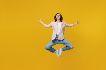 Full body spiritual tranquil young woman she 30s in striped shirt white t-shirt hold spreading hands in yoga om aum gesture relax meditate try to calm down isolated on plain yellow background studio