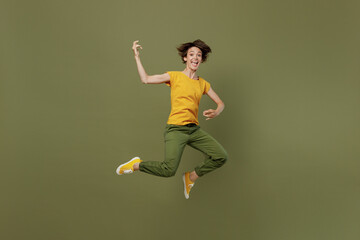 Full size young expressive singer happy woman she 20s wear yellow t-shirt jump high play guitar...
