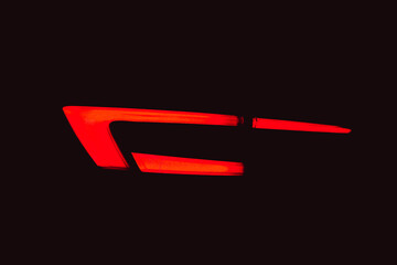 Rear red car LED lights in the dark. Bright modern car headlights on a black background. Background bright red LED car taillights in the dark. Diode stop light. 