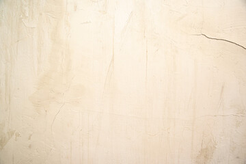 Textured  abstract pastel beige background with stains and  cracks.
