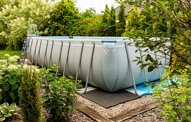 Above ground, rack swimming pool in the garden. Summer holiday recreation.