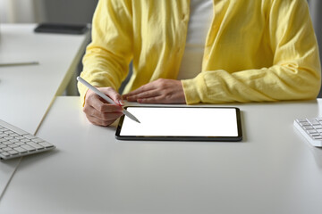 Close up with businesswoman using stylus pen writing or drawing on empty white screen of digital...