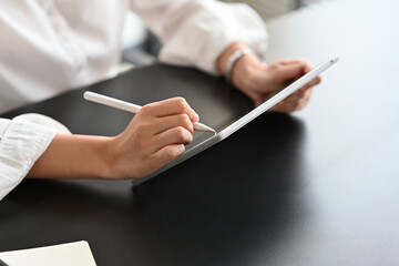 Cropped shot of businesswoman using stylus pen and digital tablet.