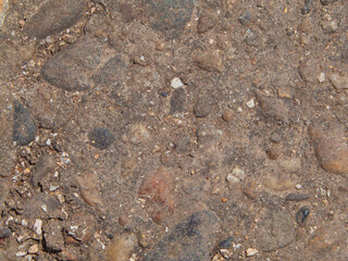Abstract background with the texture of natural stones on the soil. Natural texture of a rocky path in close-up