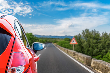 Red car on the background of the highway.