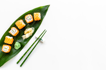 Sushi roll set with chopsticks on green Bamboo leave, top view