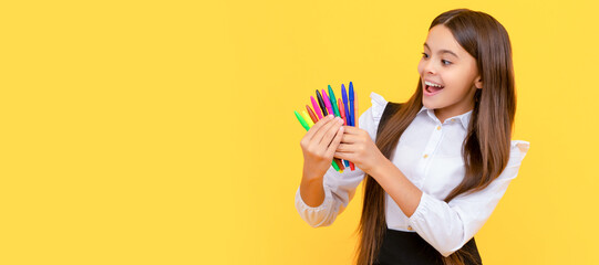 Happy girl child hold felt-tips yellow background, school stationery. Banner of school girl student. Schoolgirl pupil portrait with copy space.