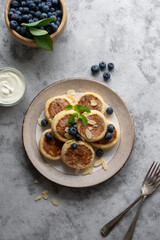 Cottage cheese fritters, ricotta pancakes with sour creamand bleberries. Healthy food. Top view.