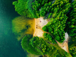 Summer holiday at the green lake. Rest on the beach, leisure time. Aerial view of small hidden beach surrounded by greenery. - obrazy, fototapety, plakaty