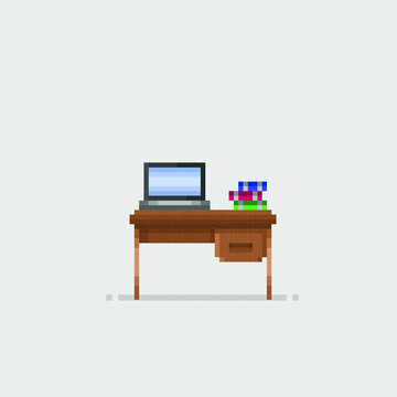 laptop and book on table in pixel art style