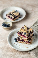 Fototapeta na wymiar Homemade blueberry crumble bars on a plate for breakfast with napkin. Healthy comfort food concept