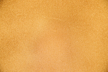 Abstract background made of foam sponge, painted in gold color. Uneven surface. Festive texture.