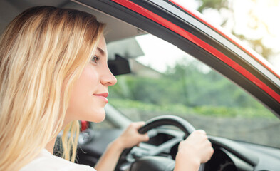 Beautiful blonde driving a car on the road.
