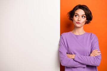 Photo of minded clever person folded hands look empty space brainstorming isolated on orange color background