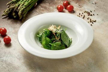 Spinach salad with crispy onions and cheese. Selective focus, shallow depth of field. Noise in post-production