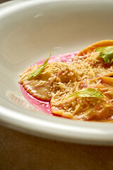 Ravioli with stuffing in pink sauce. Close-up. Selective focus. Noise in post-production