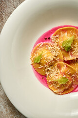 Ravioli with stuffing in pink sauce. Close-up. Selective focus. Noise in post-production