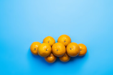 Top view of natural tangerines on blue background.