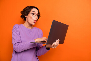 Photo of impressed person hold use wireless netbook pouted lips isolated on orange color background