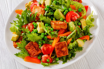 tofu salad with greens and vegetables on plate