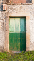 Puerta de madera verde de dos tonos en casa rural