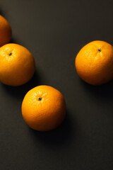 Top view of fresh and natural tangerines on black background.
